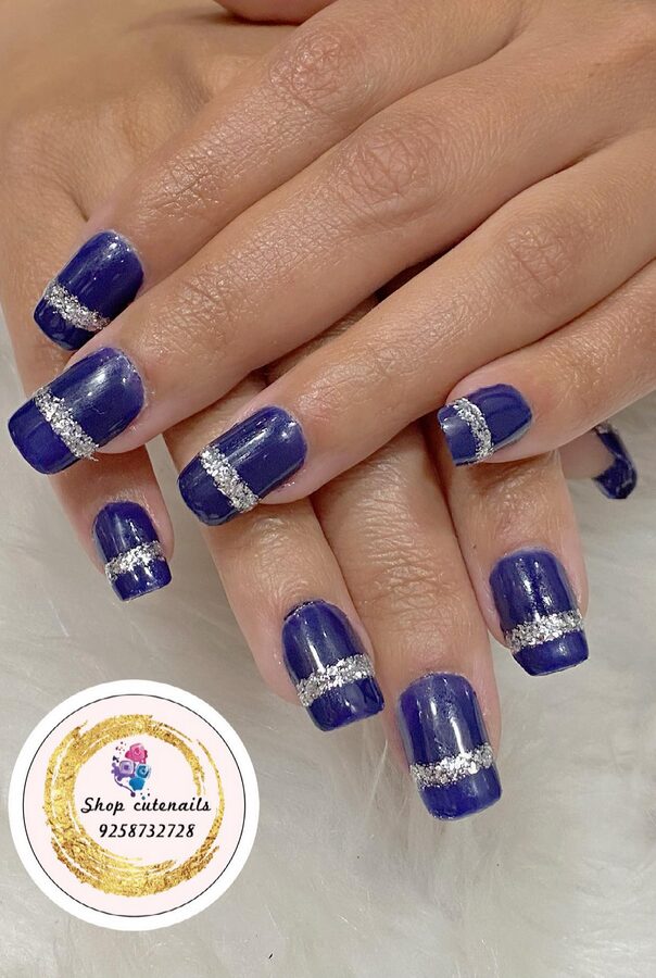 Deep navy blue nails with silver metallic accents