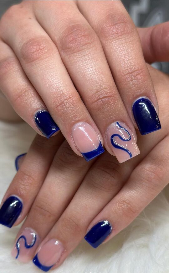 Square-shaped nails painted in glossy navy blue