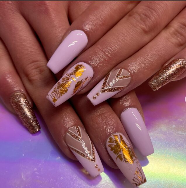 nails with blush pink polish, gold foil accents, and geometric metallic designs