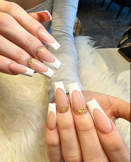 nails with classic white French tips and gold foil accents near the cuticles