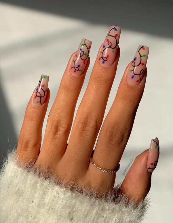 nails with a nude base featuring playful Christmas light string designs in red, blue, green, and yellow