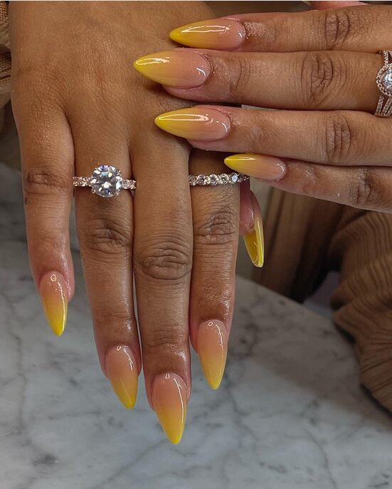 Almond nails with nude to yellow ombre gradient and glossy finish