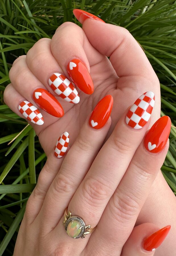Nails with alternating orange and white checkerboard design