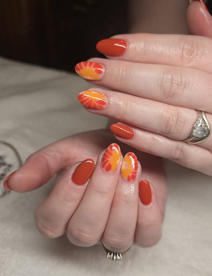 orange daisy nails closeup