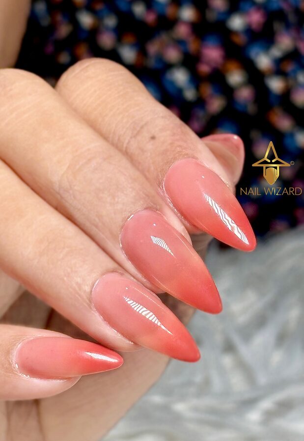 Nails ombré from peach tone at base to vibrant orange tips