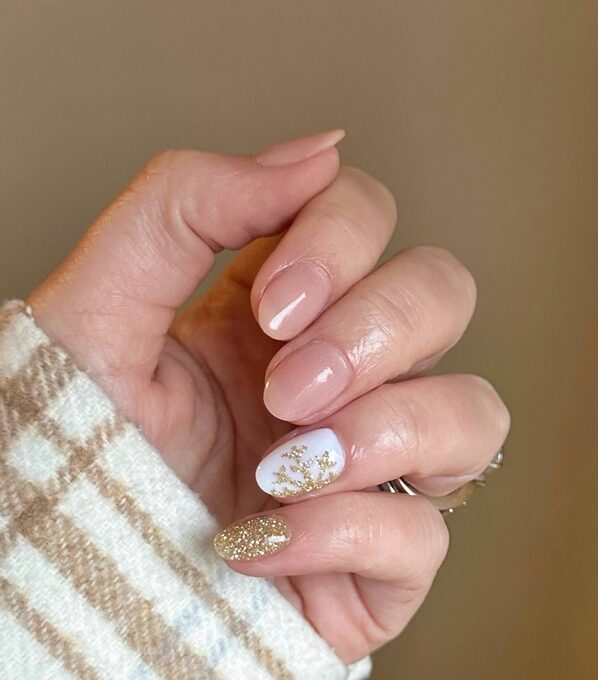 Short neutral nails with a gold glitter accent