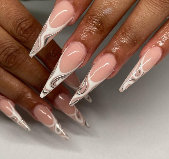 pointy nails featuring a glossy nude base with elegant white and silver marble swirl tips