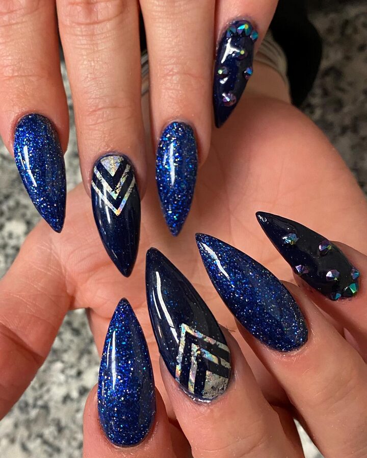 Stiletto-shaped nails painted in glossy navy blue