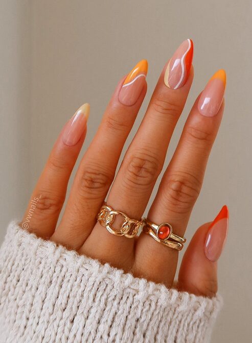 Nude base nails with bright orange swirl designs