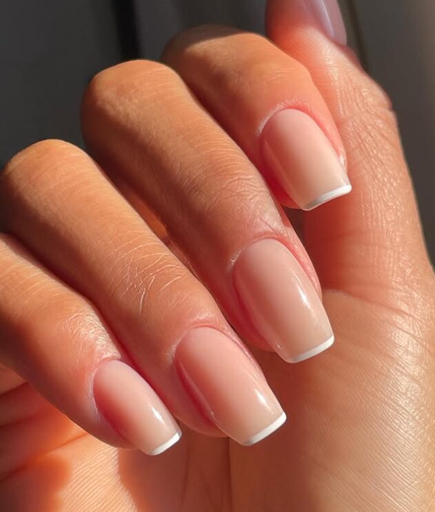 Elegant manicured nails featuring ultra-thin white lines at the tips