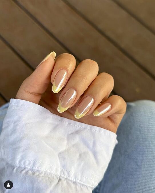 Glossy nude nails with soft yellow French tips