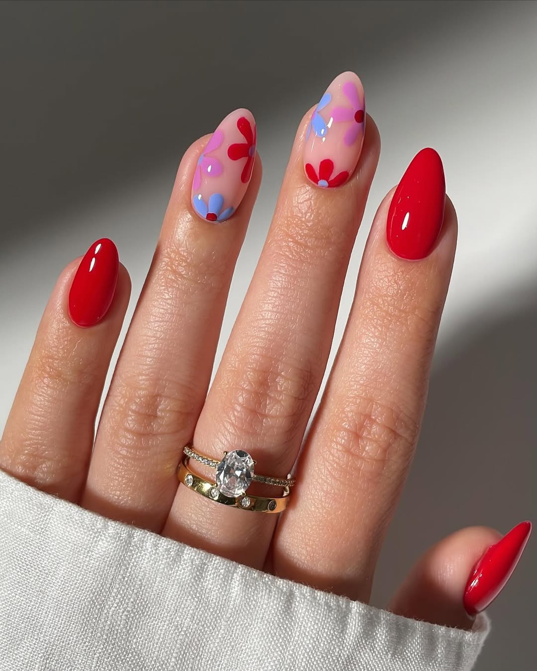 glossy red spring nails with colorful floral accent