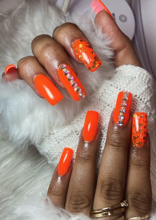 Burnt orange nails with pearl embellishments on coffin shape