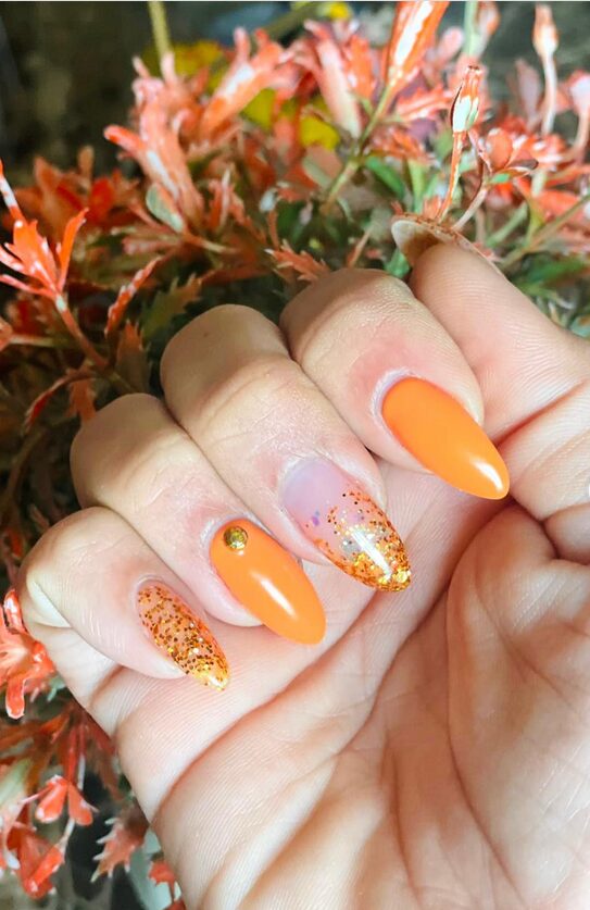 Ombre nails blending burnt orange to nude