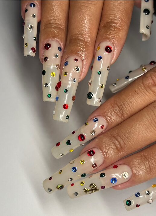 long nude coffin nails decorated with multicolor crystal dots