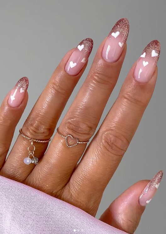 sparkly nude nails with glitter heart accents