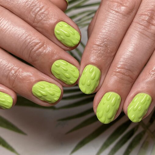 Dripping nails with glossy green polish and melting paint effect