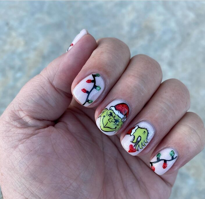 heart nails with Grinch artwork on nude base
