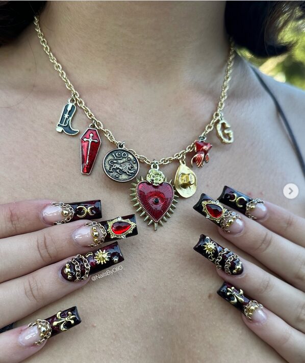 Black nails with gold chain accents