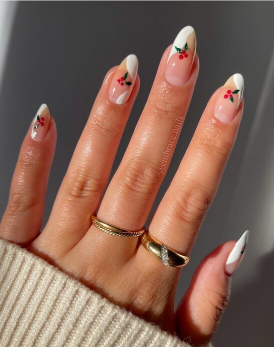 Sheer nude nails with tiny green mistletoe leaves and red berry accents