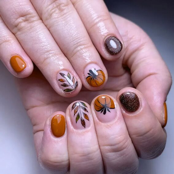 Orange nails with cute pumpkin accent nail art