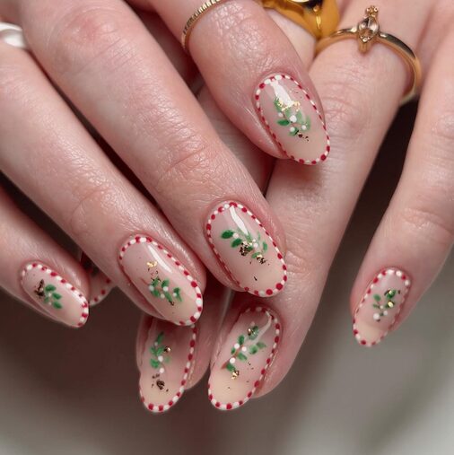 Close-up of dotted candy cane nails with red, white, and silver dots