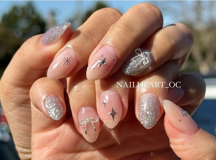 Neutral nails decorated with thin silver metallic ribbons