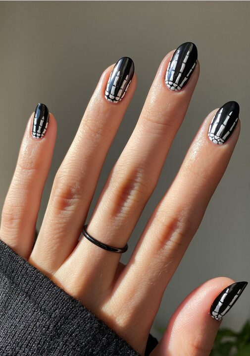 Black Halloween nails with white skeleton hand-painted designs