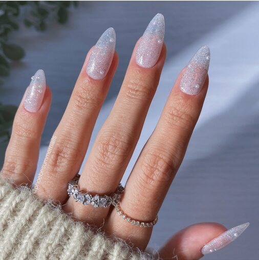Close-up of sheer sparkle nails with a translucent base and fine glitter