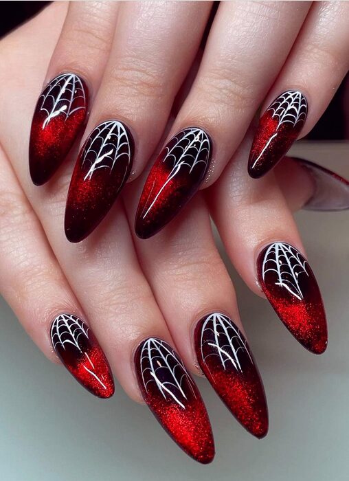 Halloween nails with black spiderweb designs over red base