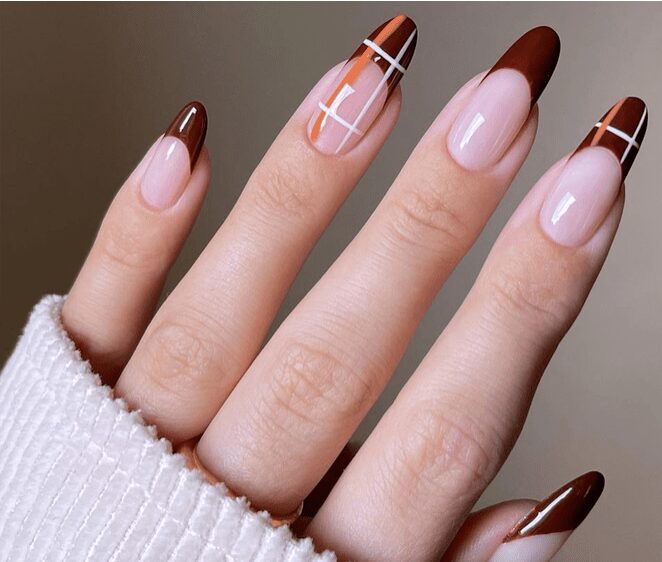 Fall striped French tip nails with terracotta, rust, and brown stripes