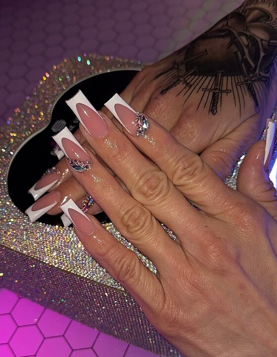 long white French tip nails with nude bases and crystal rhinestone accents