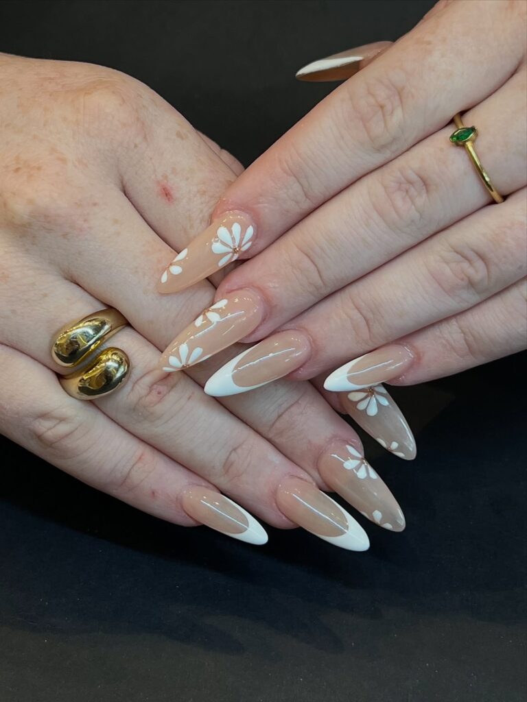 nails alternating white French tips and hand-painted white daisy nail art