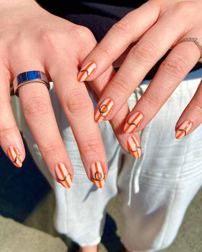 orange stripe nails with gold waves