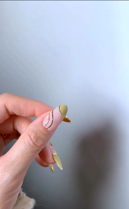 Nude and gold asymmetrical nails with fine gold swirl accents