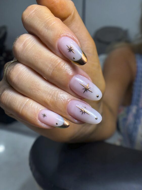 nails with gold star accents and metallic tips