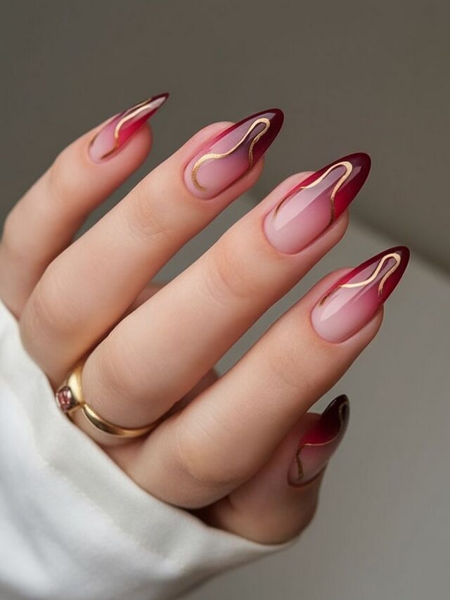 Deep red French tips with elegant gold swirl designs
