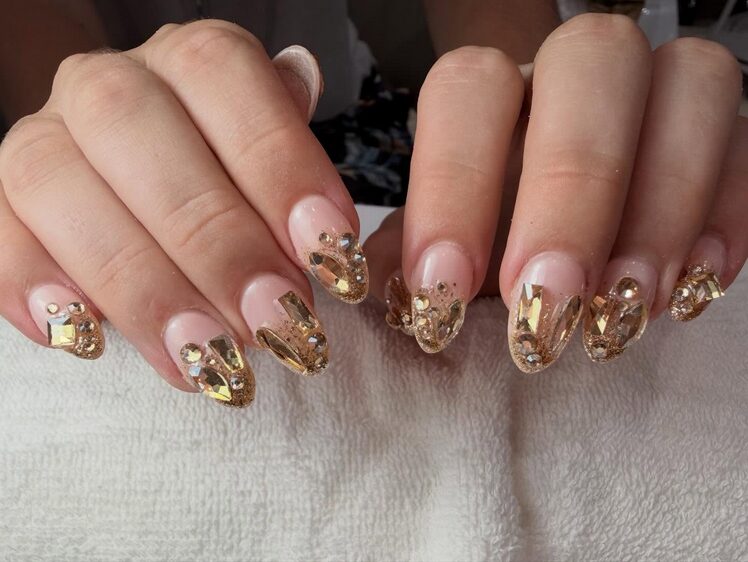 Nude nails with fully embellished gold crystal tips