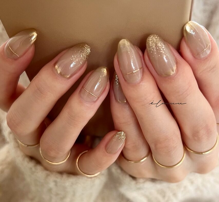 Neutral nails with soft gold glitter gradient French tips
