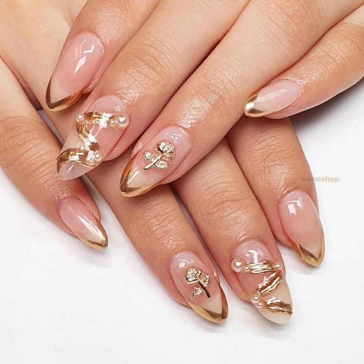 nails with rose gold French tips, pearls, and metallic floral accents