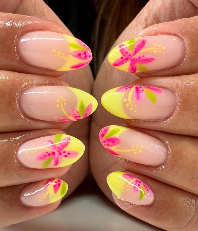 nails with bright yellow French tips decorated with pink tropical flowers and green leaves