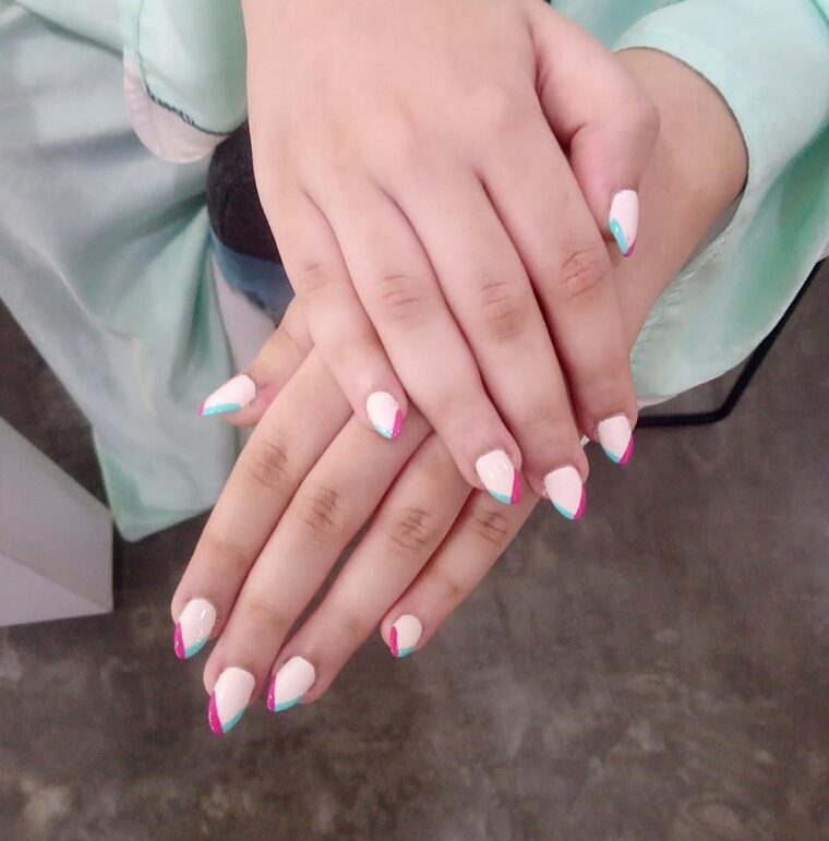 Two-tone French tips in pink and teal on nude nails