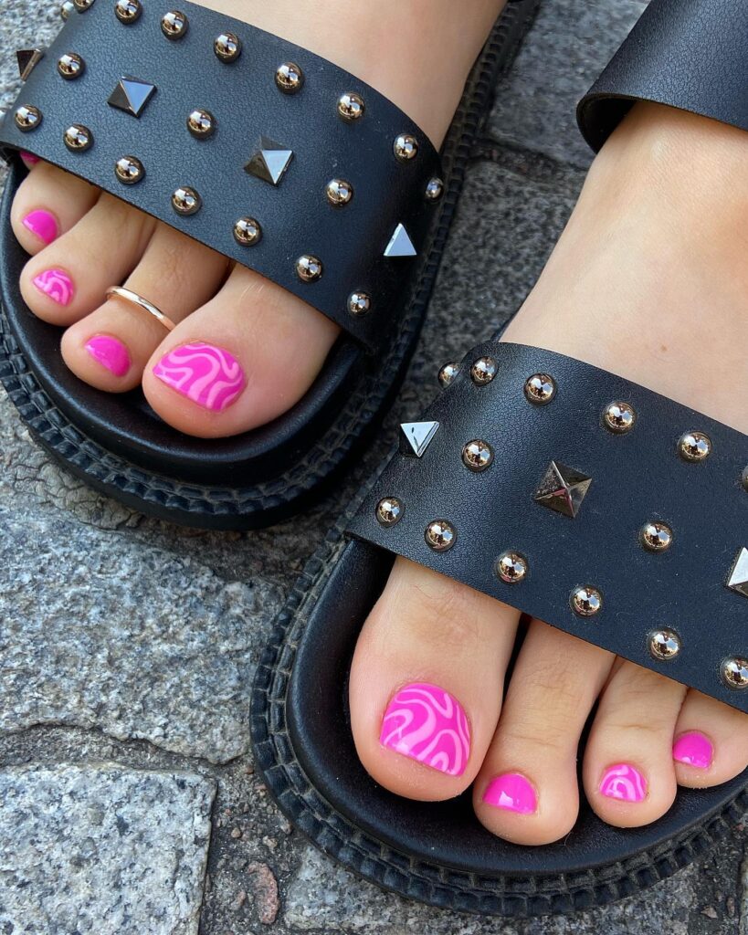 hot pink pedicure with swirl marble art