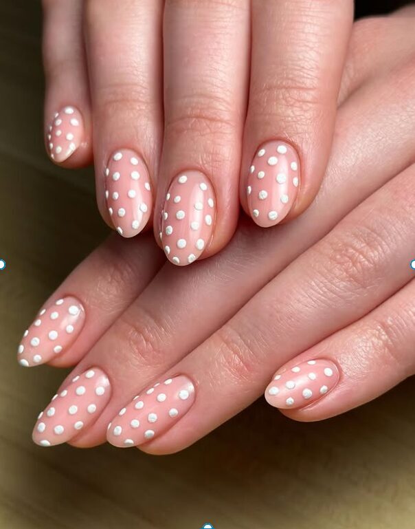 closeup of nails with tiny white dots on pink base