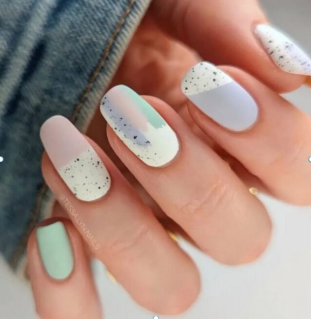 pastel abstract nails with speckled details in mint, nude, and soft lavender tones