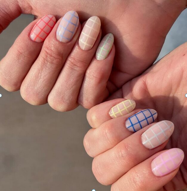Soft pastel nails with colorful grid patterns in pink, blue, yellow, and green tones