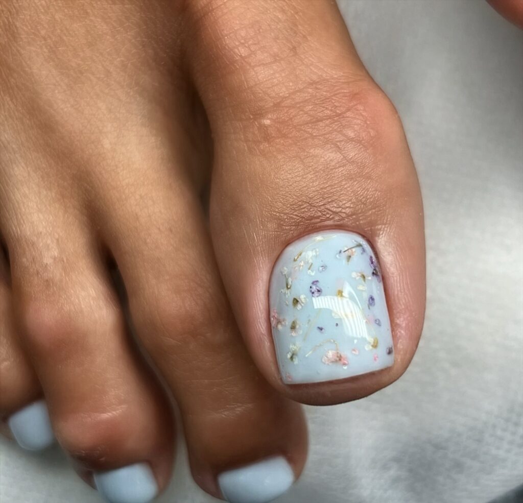 periwinkle blue pedicure with pressed dried flower art