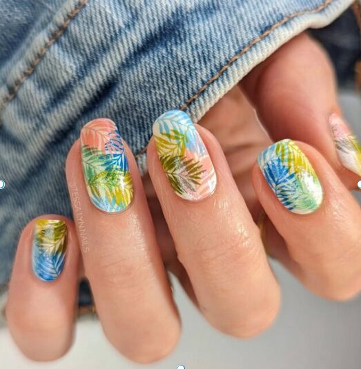 colorful tropical leaf nails with blue, green, and yellow palm designs on a glossy base
