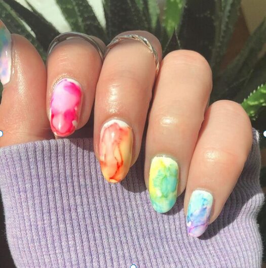 colorful watercolor nails in pink, orange, yellow, green, and blue