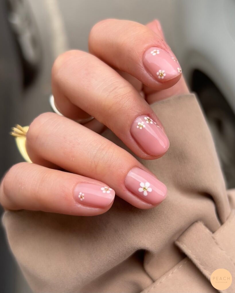Blush pink nails with white daisy and gold centre art